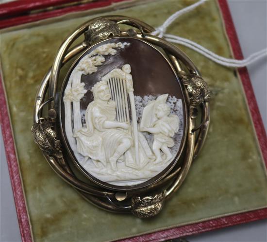 A cased Victorian 9ct gold mounted oval shell cameo brooch, depicting King David singing psalms, 66mm.